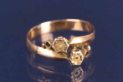 une bague en or sertie de trois diamants sur un fond bleu