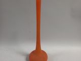 an orange vase that is sitting on a white surface