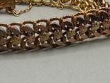 a close up of a bracelet with a brown stone on it