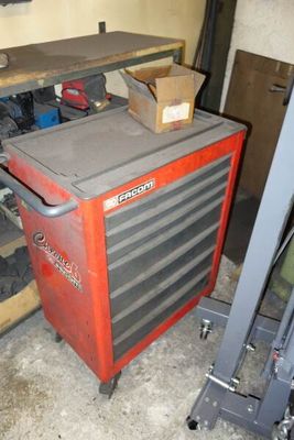 a red tool cabinet in a garage with tools on it