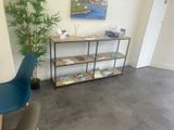 a picture of a living room with a book shelf and a blue chair