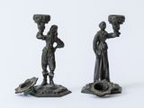 pair of bronze figurines of a woman and a man holding a bird