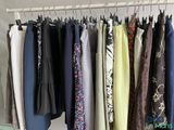 a lot of clothes hanging on a rack in a room