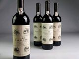 quatre bouteilles de vin sont alignées sur une table