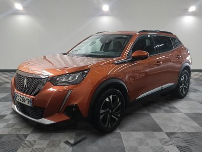 Le SUV orange est garé dans le garage, sur un sol à damier.