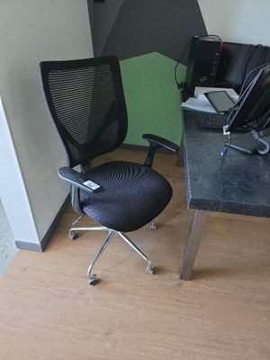 un bureau d'ordinateur avec une chaise et un ordinateur portable posé dessus