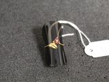 un petit objet noir orné d'une fleur rose