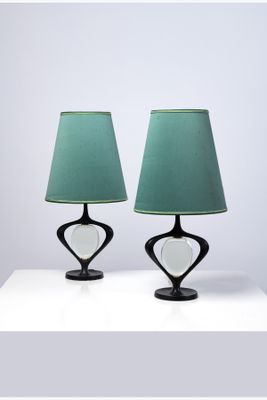 une paire de lampes de table noires avec des abat-jours verts, posées sur une surface blanche