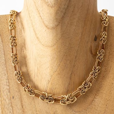 un gros plan sur un mannequin portant un collier à chaîne en or