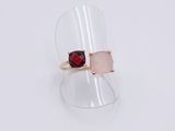 a close up of a ring with a red stone on it