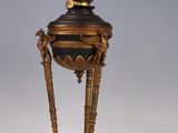 an old fashioned lamp on a white surface with a gray background