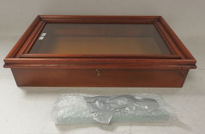 a wooden box with a glass lid and a plastic bag