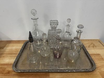un plateau en argent sur lequel sont posées des bouteilles en verre, posé sur une table en bois