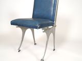 a blue leather chair with wheels on a white background
