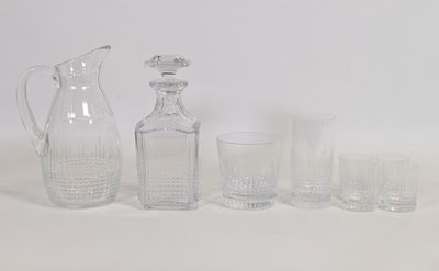 des bouteilles et des verres sont alignés sur une surface blanche