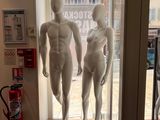 deux mannequins qui se tiennent devant une vitrine
