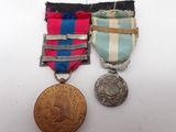 two medals and a medal on a white surface