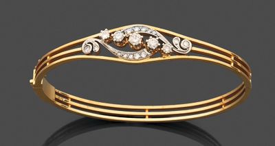 un gros plan d'un bracelet en or serti de diamants sur un fond noir