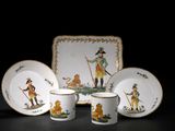 un ensemble d'assiettes et de tasses ornées d'une image représentant un homme et un chien