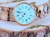 a clock that is sitting on a piece of wood