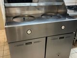 a stainless steel kitchen with two sinks and a stove