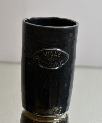 a black cup sitting on top of a white table