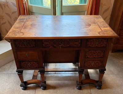 une table en bois avec un plateau sculpté et des tiroirs