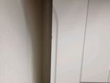 a small white cabinet in the corner of a room
