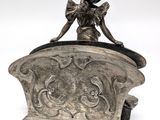 a silver statue of a girl sitting on top of a box