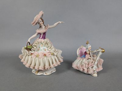 pair of porcelain figurines of a woman in a pink dress and a lady in a white dress