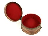 a small round box with a red lid on a white surface