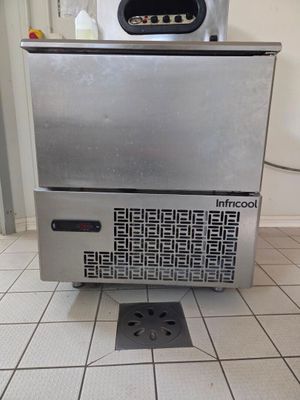 an image of a stainless steel ice maker on a tiled floor