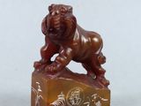 two chinese carved figurines of a lion on a rock