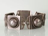 bracelet en métal argenté et perles de verre sur un fond blanc