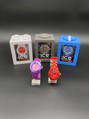 trois montres différentes sont posées les unes à côté des autres sur une table