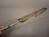 a silver spoon with a handle that has a flower design on it
