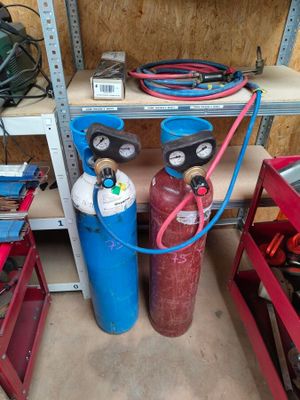 two propane gas bottles and a hose in a garage