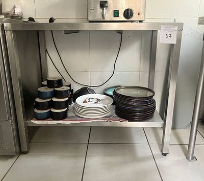 de nombreuses assiettes et casseroles posées sur une étagère dans la cuisine