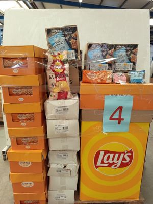 des paquets de chips empilés sur un chariot dans un magasin