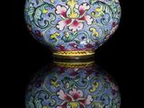 a blue vase with flowers on it on a black surface
