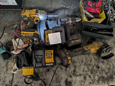 a pile of power tools on the floor in the garage
