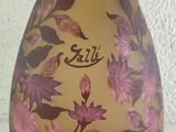 a yellow vase with pink flowers on it on a white surface