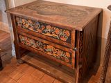 a small chest of drawers that has a floral design on it
