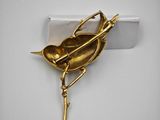 gold plated bird brooch on a branch with a twig