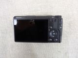 a small black camera sitting on a white surface