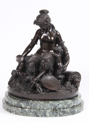 bronze statue of a woman sitting on a rock with a dog
