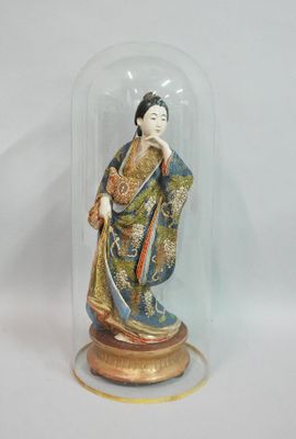 a figurine of a woman under a glass dome