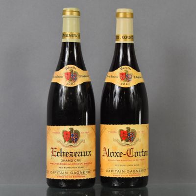 two bottles of wine sitting on top of a table next to each other