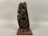 une sculpture en bois représentant une femme tenant un enfant dans ses bras