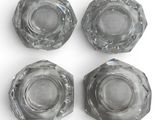 four clear glass knobs on a white surface with a white background